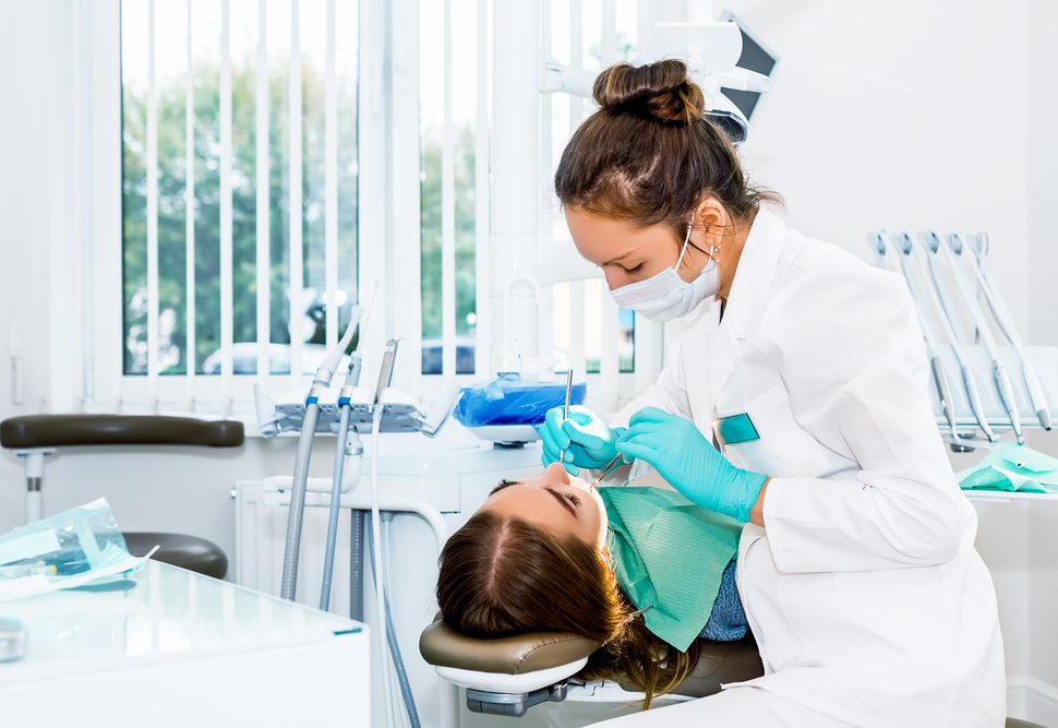 female dentist performs dental exam