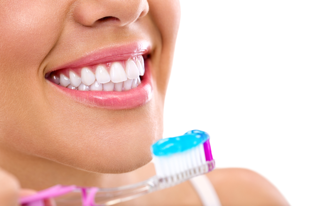 smiling young woman about to brush teeth